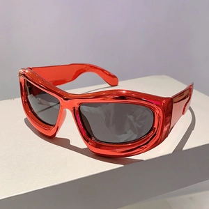 Detail of red metallic Y2K futuristic sunglasses on a white minimalist display stand