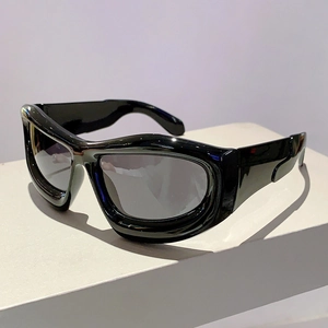 Detailed close-up of glossy black wide-frame Y2K bubble sunglasses on a white pedestal