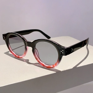Detail view of round tortoiseshell sunglasses with gradient frames and silver triple rivets