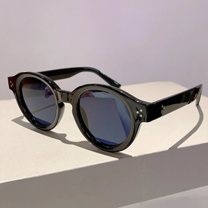 Detail of round sunglasses with silver rivets and model number on inner temple arm