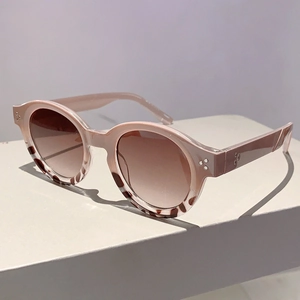 Detail of round sunglasses with nude pink frame and tortoiseshell pattern accents