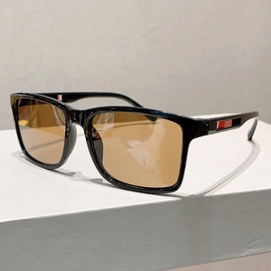 Détail de lunettes de soleil carrées avec monture noire et motif à rayures sur les branches
