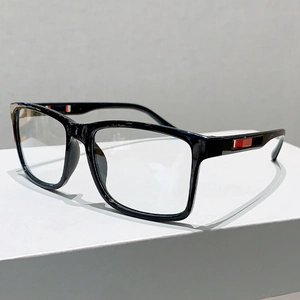 Détail de lunettes de soleil noires carrées avec accents rouges sur les branches