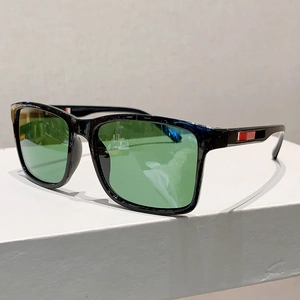 Lunettes de soleil carrées noires avec verres verts et détail de branche rayée