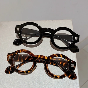 Retro round tortoise and black blue light glasses with silver studs on stone display