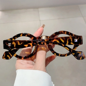 Detailed close-up of tortoise shell round frame glasses with vintage square metal rivets