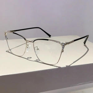 Détail de lunettes papillon en métal avec incrustations de diamants sur la monture dorée