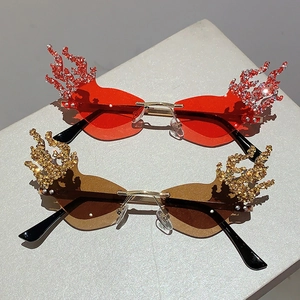 Detail of red and brown flame-shaped rimless sunglasses with rhinestone-encrusted edges