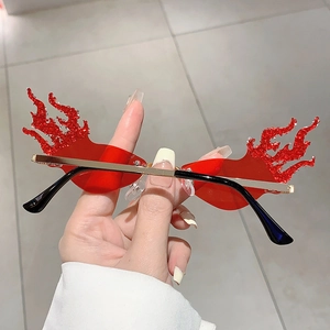 Detail shot of red flame shaped rimless sunglasses with sparkling red glitter edges