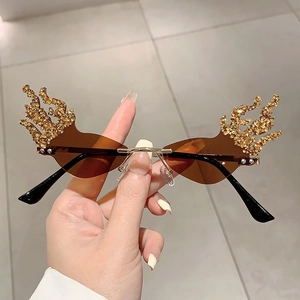 Close-up of flame shaped rimless sunglasses with gold rhinestones and brown lenses