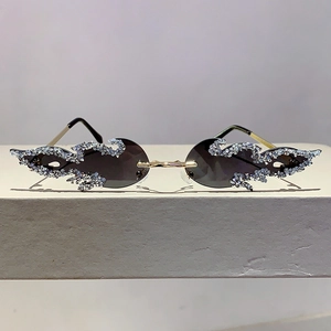 Fashionable flame-shaped sunglasses with sparkling rhinestones and golden metal frame