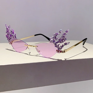 Detailed side view of purple flame-shaped rimless sunglasses with sparkling crystals
