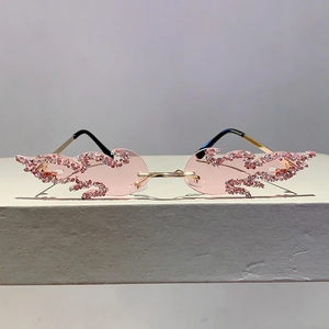 Close-up of pink flame-shaped rimless sunglasses with hand-set rhinestones and gold temples