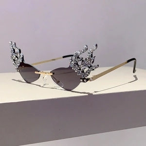 Detail of flame-shaped rhinestones on purple rimless fashion sunglasses with gold temples