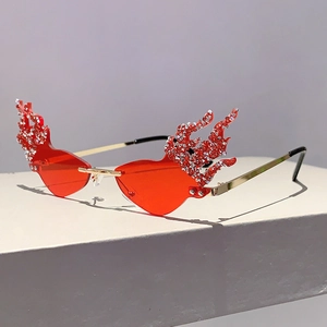 Close-up of red flame-shaped rimless sunglasses with sparkling silver diamond accents