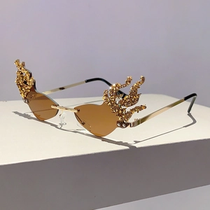 Close-up of rimless flame-shaped sunglasses with amber lenses and gold crystal accents
