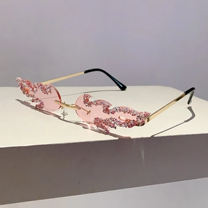 Close-up of pink flame-shaped rimless sunglasses with sparkling rhinestone details