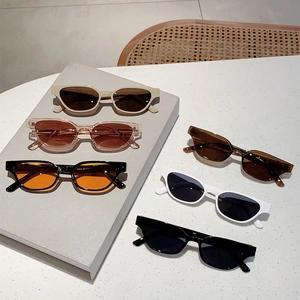 Various cat-eye and rectangular sunglasses arranged on a textured stone surface