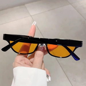 Close-up of retro cat-eye sunglasses with black frames and translucent orange lenses