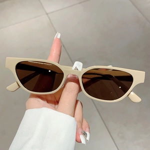Detail of trendy milk tea beige cat eye sunglasses with thick frames and dark lenses