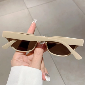 Detail view of vintage beige cat-eye sunglasses with thick frames and dark lenses