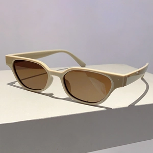Detail view of cream cat-eye sunglasses with brown lenses on a geometric stand
