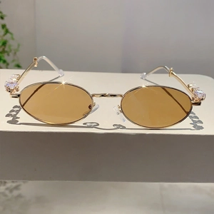Occhiali da sole ovali dorati con stanghette in strass e lenti marrone chiaro