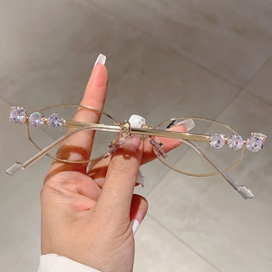 Dettaglio degli occhiali da sole in metallo dorato con aste lussuose con strass