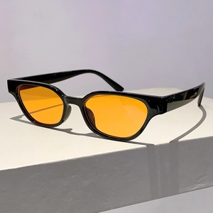 Side view of retro cat-eye sunglasses with thick black frames and vibrant orange lenses