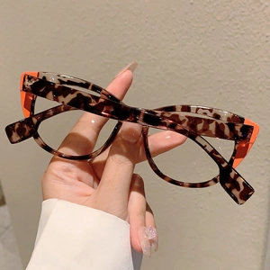 Detail of tortoise shell cat-eye glasses with striking orange patchwork accents