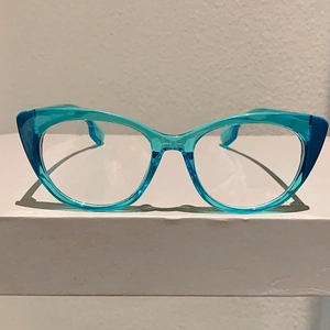 Close-up of cat-eye frames in translucent turquoise with dark blue spliced accents