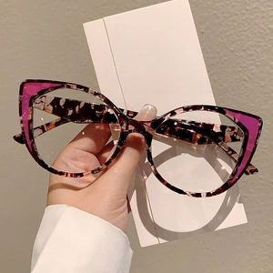 Detail of tortoiseshell cat-eye glasses with pink accents and oversized frames