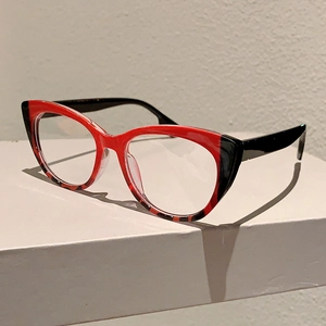 Detailed side view of cat-eye glasses with red top frame and leopard print lower part
