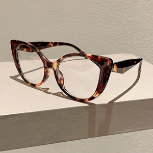 Detail view of cat eye tortoise glasses with geometric temples on a white pedestal