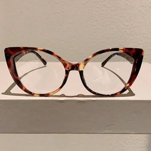 Front view of retro cat-eye glasses frame with leopard print pattern on white pedestal