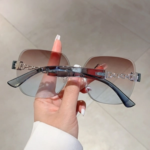 Close-up of frameless sunglasses with gradient lenses and silver chain metal temples