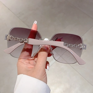 Detail view of rimless sunglasses with gradient lenses and stylish metal chain link temples