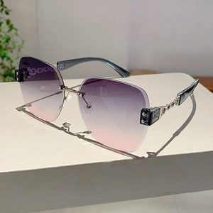 Detail view of purple-pink gradient lenses and stylish gold metal chain temples on sunglasses