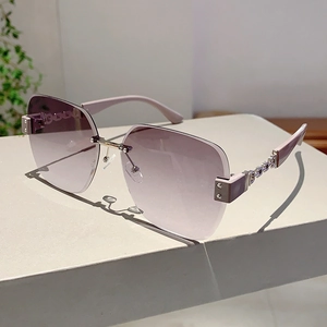 Detail of rimless sunglasses with purple gradient lenses and rhinestone chain temples