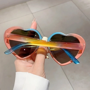 Detailansicht der trendigen herzförmigen Sonnenbrille mit buntem Regenbogen-Farbverlauf.