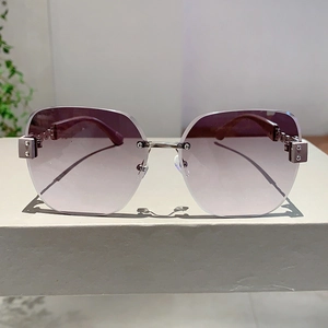Close-up of rimless sunglasses featuring purple gradient lenses and silver metal hinges