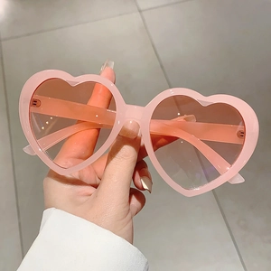 Trendige herzförmige Sonnenbrille mit rosa transparentem Rahmen und Verlaufsgläsern