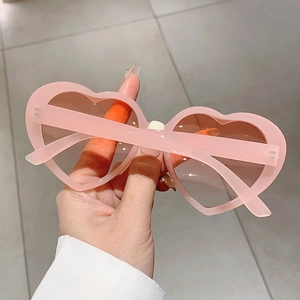 Nahaufnahme der rosafarbenen herzförmigen Sonnenbrille mit braunen Gläsern für Partys