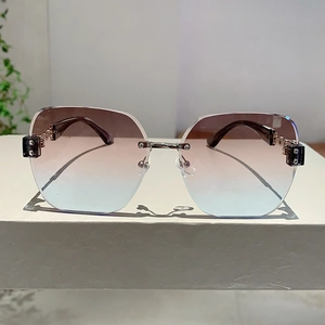 Detail of rimless gradient sunglasses with gold metal chain temple and square accent