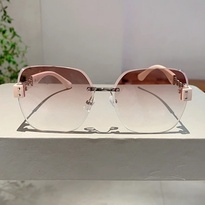 Frameless rimless sunglasses with pink gradient lenses and elegant metal chain temple details
