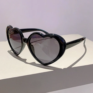 Detailansicht der herzförmigen Sonnenbrille mit schwarzem Rahmen und dunklen Gläsern