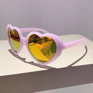 Detailansicht der rosa Herz-Sonnenbrille mit gelben Spiegelgläsern auf einem Display-Ständer