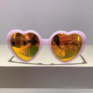 Vorderansicht der herzförmigen Sonnenbrille mit rosa Rahmen und orangefarbenen Gläsern