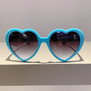 Detailansicht der hellblauen Herz-Sonnenbrille mit dunklen Verlaufsgläsern für Partys
