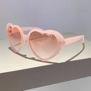 Detailansicht der herzförmigen Sonnenbrille mit hellrosa Rahmen und Verlaufsgläsern